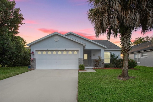 ranch-style house with a garage and a lawn