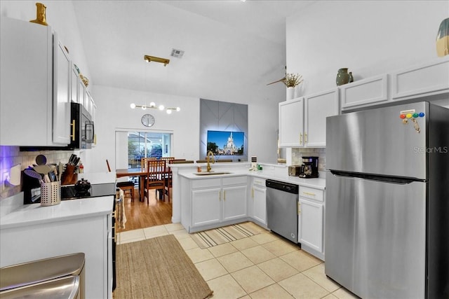 kitchen with light tile patterned flooring, white cabinets, backsplash, kitchen peninsula, and stainless steel appliances