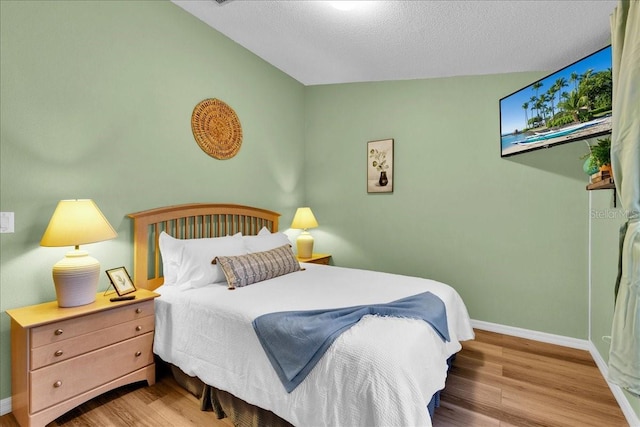 bedroom featuring hardwood / wood-style flooring and a textured ceiling