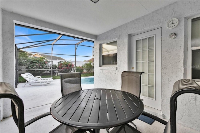 view of patio featuring glass enclosure