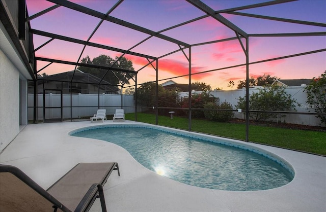 pool at dusk featuring a patio, a yard, and glass enclosure