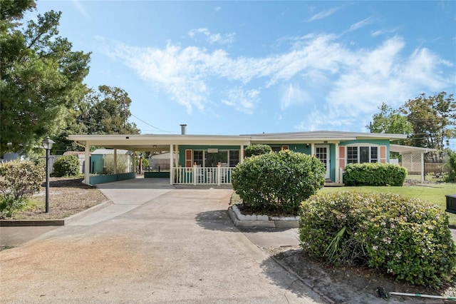 exterior space featuring concrete driveway, a carport, and fence