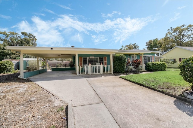 view of front of home with an attached carport, a front lawn, and concrete driveway