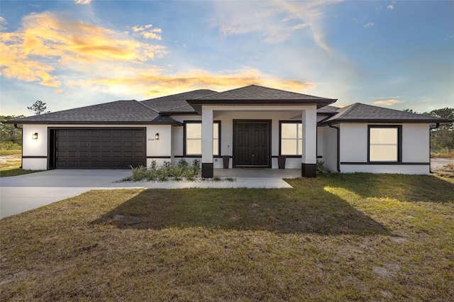 prairie-style home featuring a yard and a garage