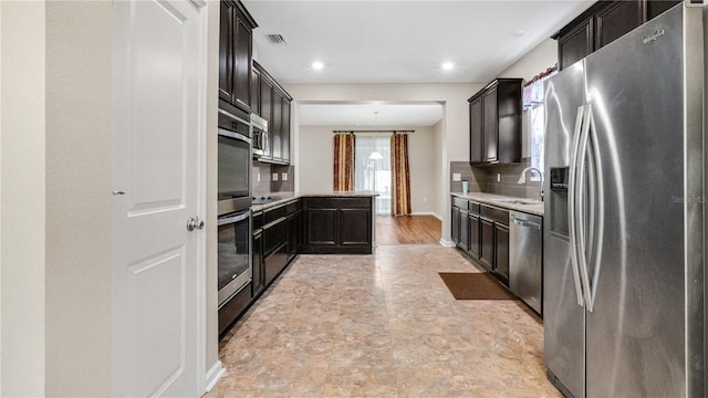 kitchen with appliances with stainless steel finishes, sink, and decorative backsplash