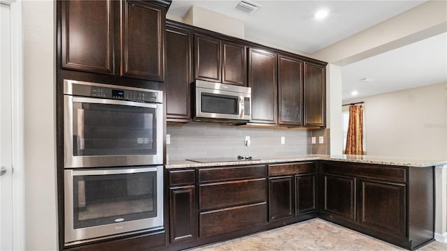 kitchen with decorative backsplash, dark brown cabinets, and appliances with stainless steel finishes