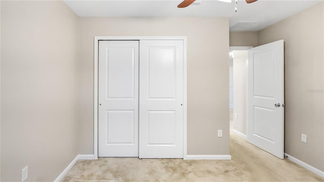 unfurnished bedroom featuring light carpet, ceiling fan, and a closet