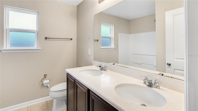 bathroom with tile patterned flooring, vanity, walk in shower, and toilet