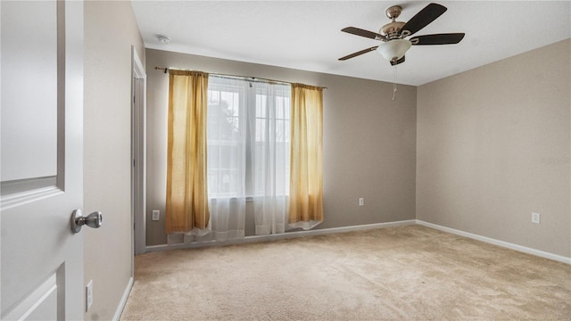 spare room featuring ceiling fan and light colored carpet