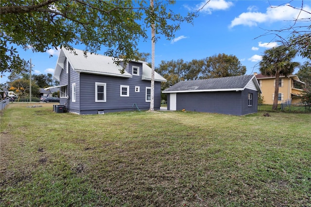 rear view of house with central AC and a yard