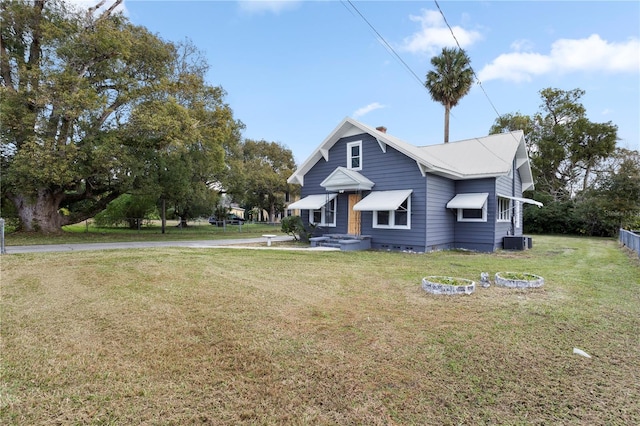 view of front of property featuring central AC unit and a front yard