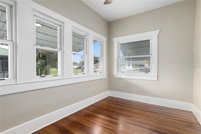 spare room with dark hardwood / wood-style flooring and ceiling fan