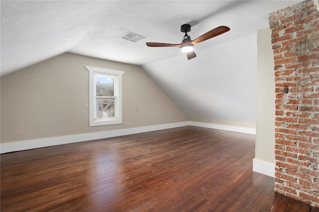 additional living space with ceiling fan, lofted ceiling, a textured ceiling, and dark hardwood / wood-style flooring