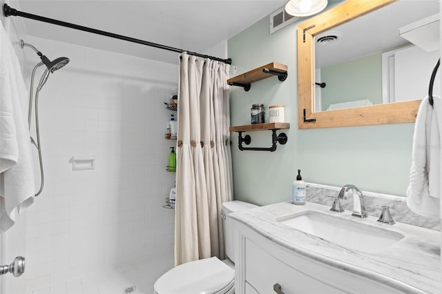 bathroom featuring toilet, a shower with shower curtain, and vanity