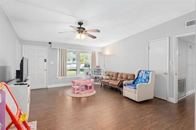 living room featuring ceiling fan and dark hardwood / wood-style flooring