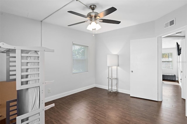 interior space with ceiling fan and dark hardwood / wood-style flooring