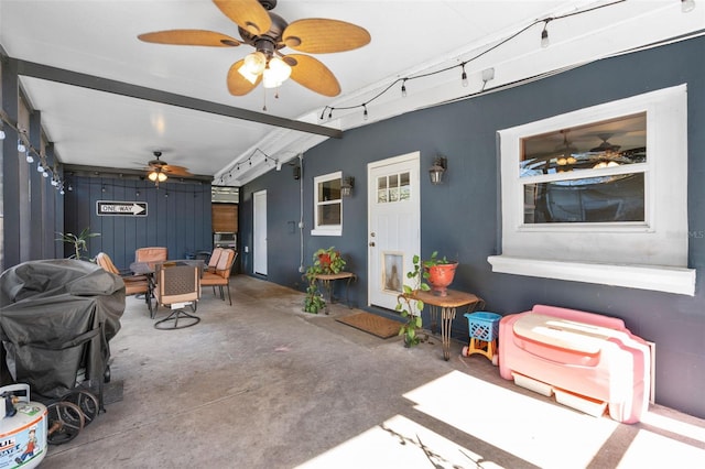 living room featuring ceiling fan and concrete flooring