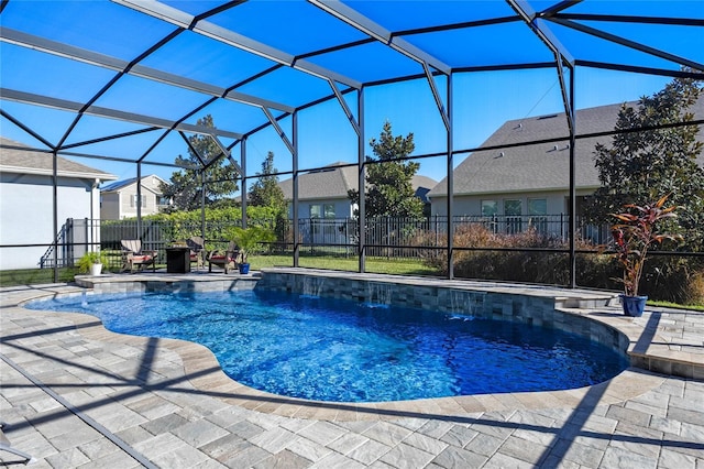 view of pool featuring glass enclosure, pool water feature, and a patio area