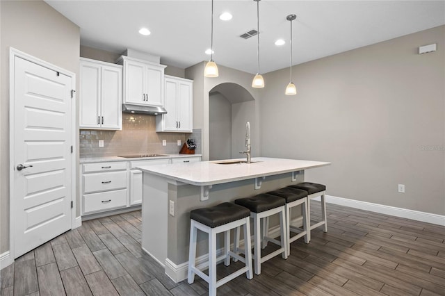 kitchen featuring a center island with sink, white cabinets, pendant lighting, and sink