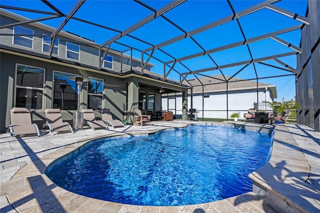 view of pool with glass enclosure and a patio area