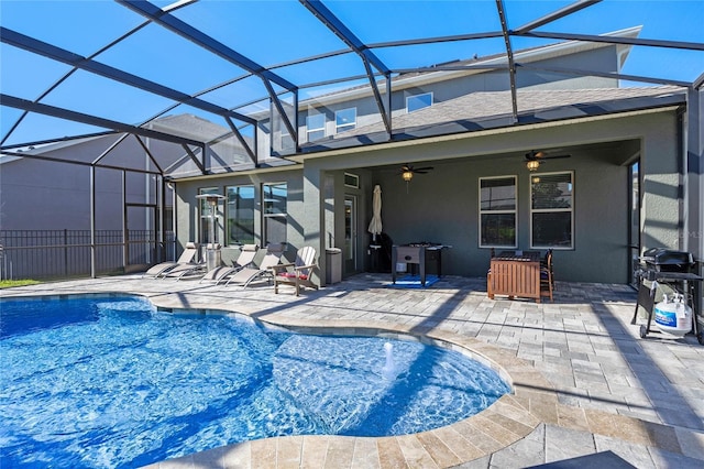 view of swimming pool featuring ceiling fan, a grill, a patio area, and glass enclosure