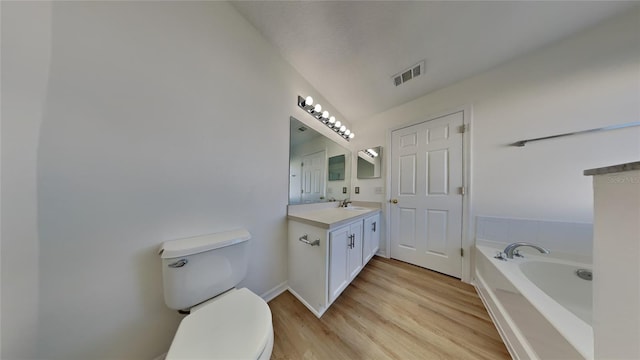 bathroom with vanity, hardwood / wood-style flooring, toilet, and a bathing tub