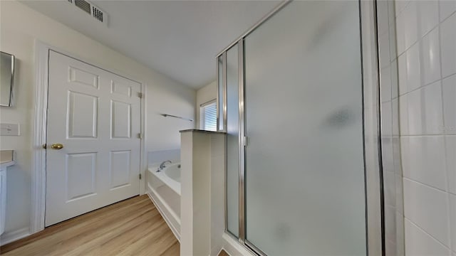 bathroom featuring hardwood / wood-style floors, vanity, and independent shower and bath