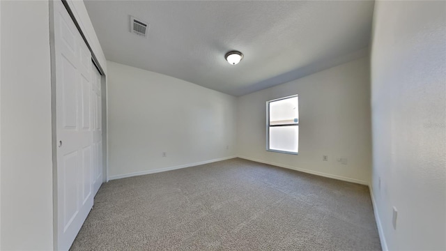 unfurnished bedroom featuring a closet, carpet, and a textured ceiling