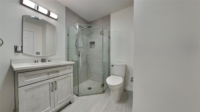 bathroom featuring vanity, toilet, and an enclosed shower