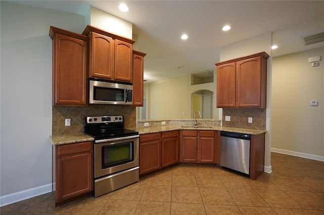 kitchen with backsplash, light tile patterned floors, sink, and appliances with stainless steel finishes