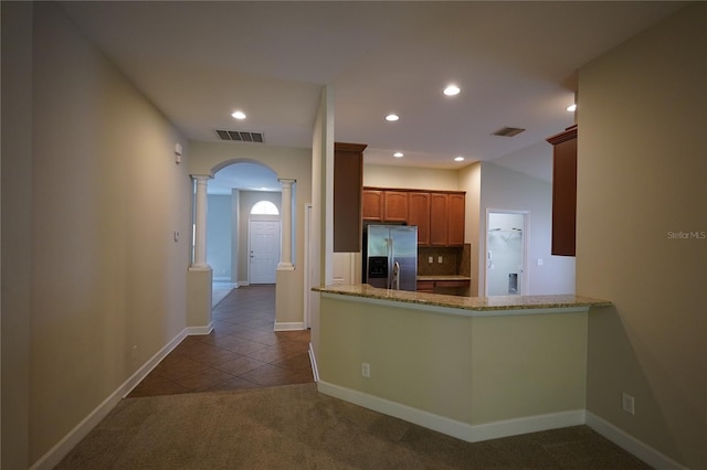 kitchen featuring backsplash, light carpet, stainless steel fridge with ice dispenser, kitchen peninsula, and ornate columns