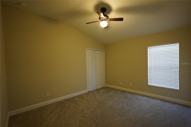 unfurnished bedroom with vaulted ceiling, a closet, ceiling fan, and carpet flooring