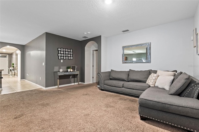 living room with a textured ceiling and light colored carpet