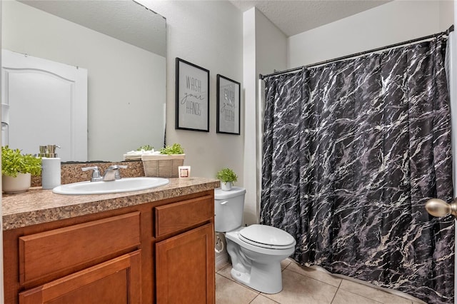 bathroom featuring toilet, tile patterned flooring, a textured ceiling, and vanity