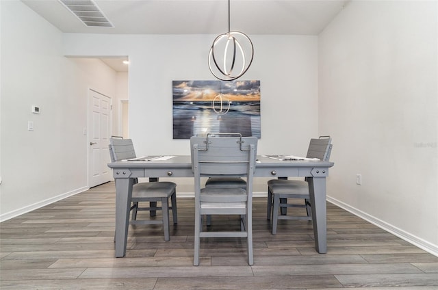 dining area with an inviting chandelier and wood-type flooring