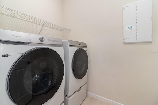 laundry area with washer and dryer and light tile patterned floors