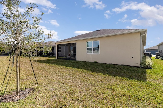 back of property with a lawn and a sunroom