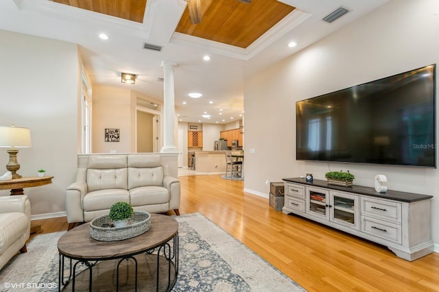 living room featuring light hardwood / wood-style floors, beamed ceiling, crown molding, coffered ceiling, and decorative columns