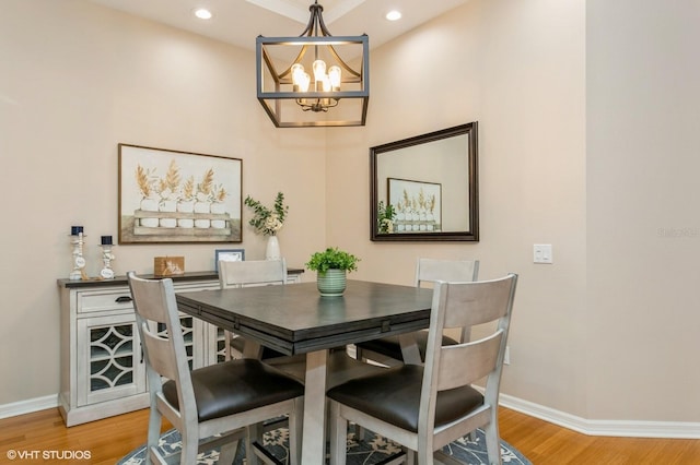 dining room with light hardwood / wood-style floors and a notable chandelier