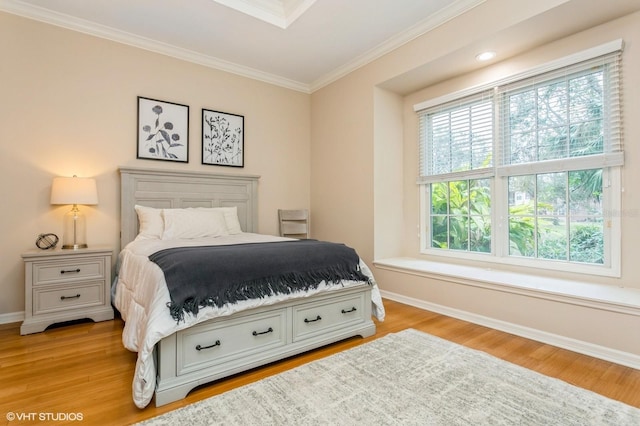 bedroom with ornamental molding and light hardwood / wood-style floors