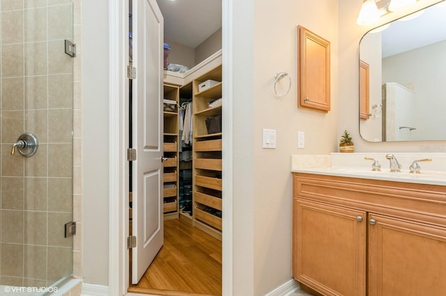 bathroom featuring vanity, wood-type flooring, and a shower with door