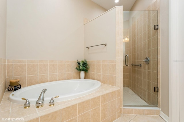 bathroom with tile patterned flooring and shower with separate bathtub