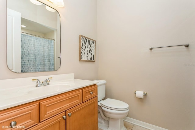 bathroom with toilet, vanity, and tile patterned flooring