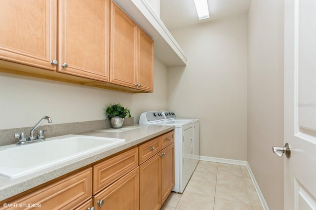 laundry room featuring light tile patterned floors, washing machine and dryer, sink, and cabinets