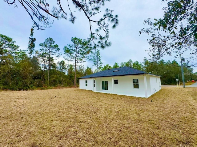 back of property with a lawn