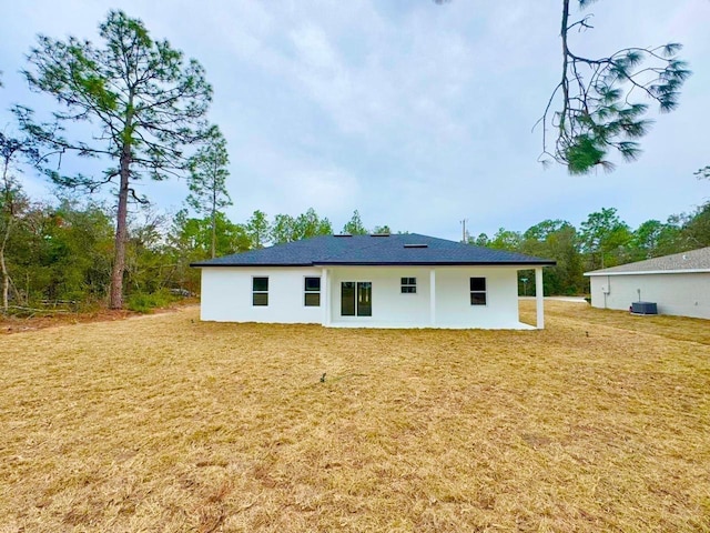 back of property with a lawn and central air condition unit