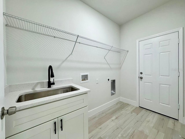 washroom with sink, electric dryer hookup, hookup for a washing machine, cabinets, and light hardwood / wood-style flooring