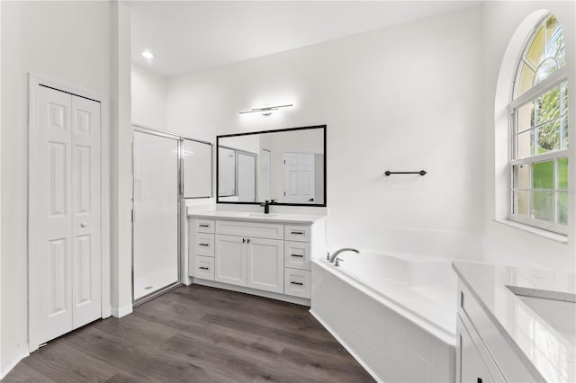 bathroom featuring hardwood / wood-style floors, vanity, and shower with separate bathtub