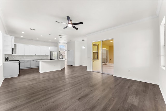 unfurnished living room featuring ceiling fan, crown molding, and dark wood-type flooring