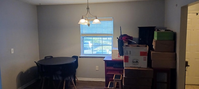 dining area with hardwood / wood-style floors and an inviting chandelier